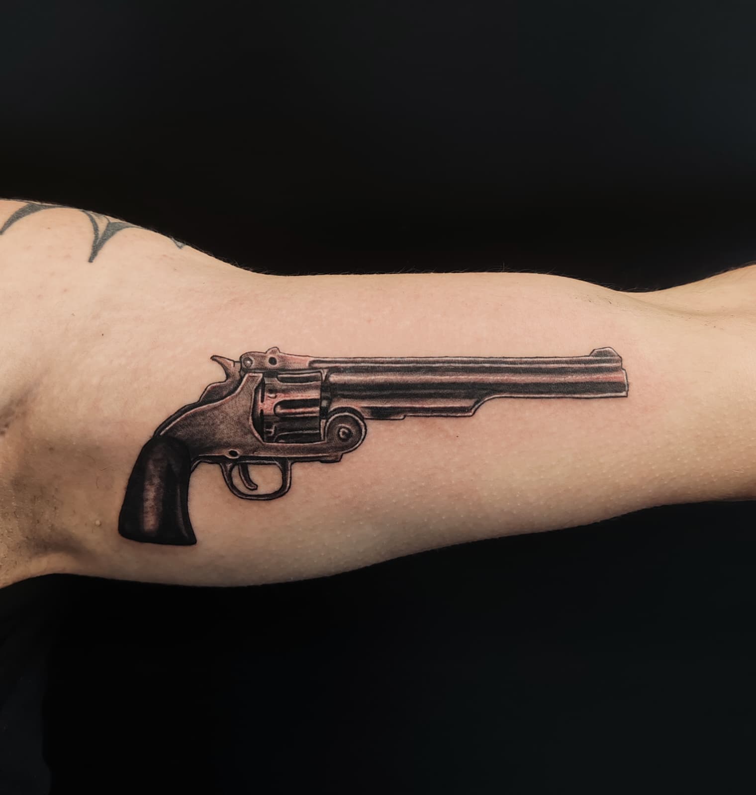 Revolver ancien sur le biceps, noir & gris — Pierre Cesbron